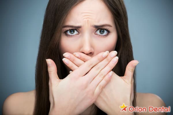 Stock image of a person covering their mouth with one hand