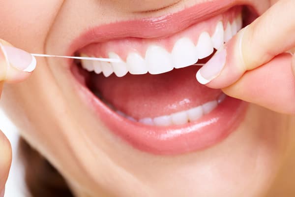 Stock image of a close-up of a person flossing their teeth