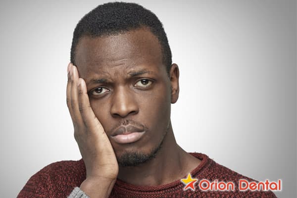 Stock image of a person holding their jaw