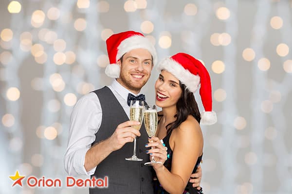 Stock image of a couple in festive holiday attire toasting with champagne