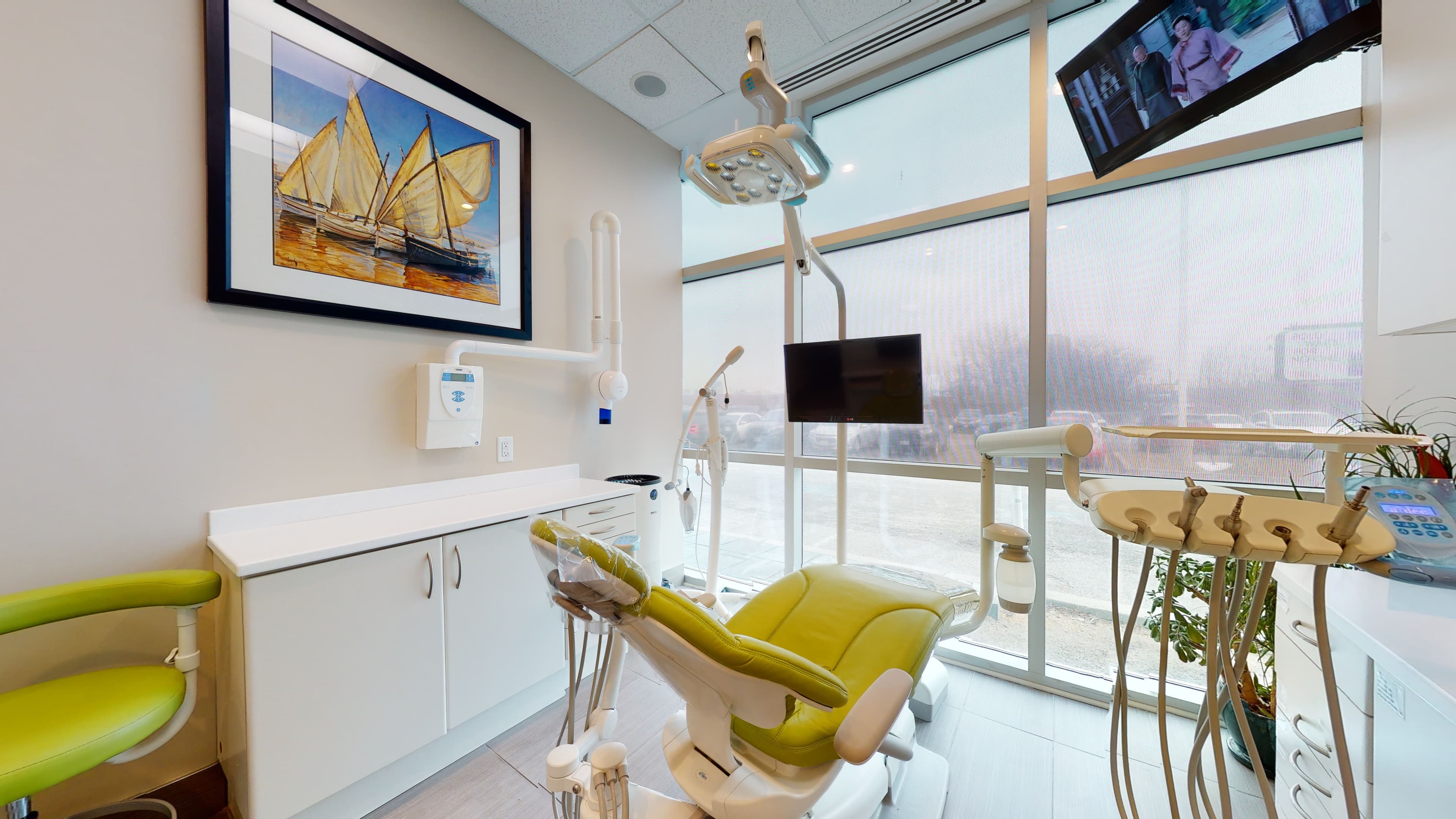 A treatment room at Orion Dental Scarborough, with a chartreuse dental chair beside a floor-to-ceiling window