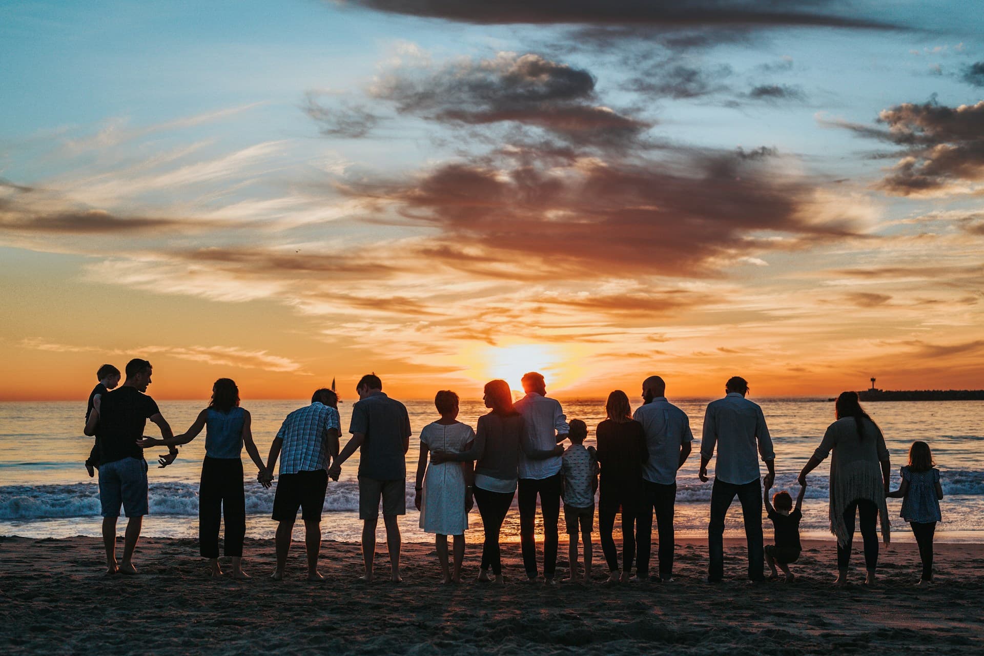 Stock image of a family silhouetted at sunset on a beach