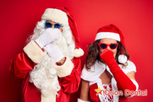 Orion Dental :: Mr. and Mrs. Claus holding noses bad breath