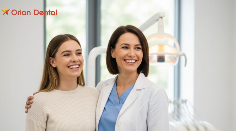 Professional dentist and patient smiling at Orion Dental clinic.